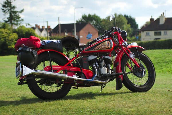 A red motorcycle is parked on the grass