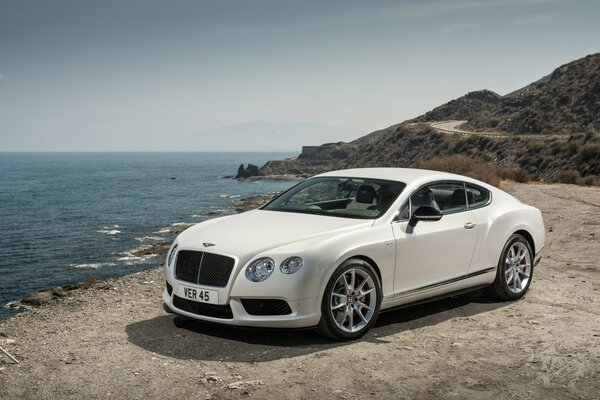 Coche bentley blanco en la orilla del mar