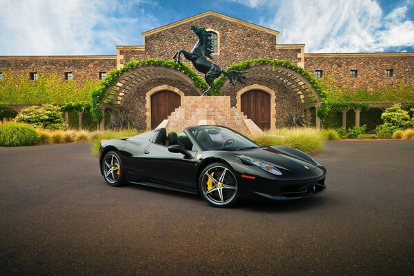 Black convertible on the background of a villa with a statue of a black horse