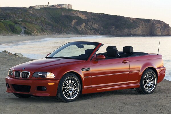 Red bmw e46 convertible on the seashore in profile