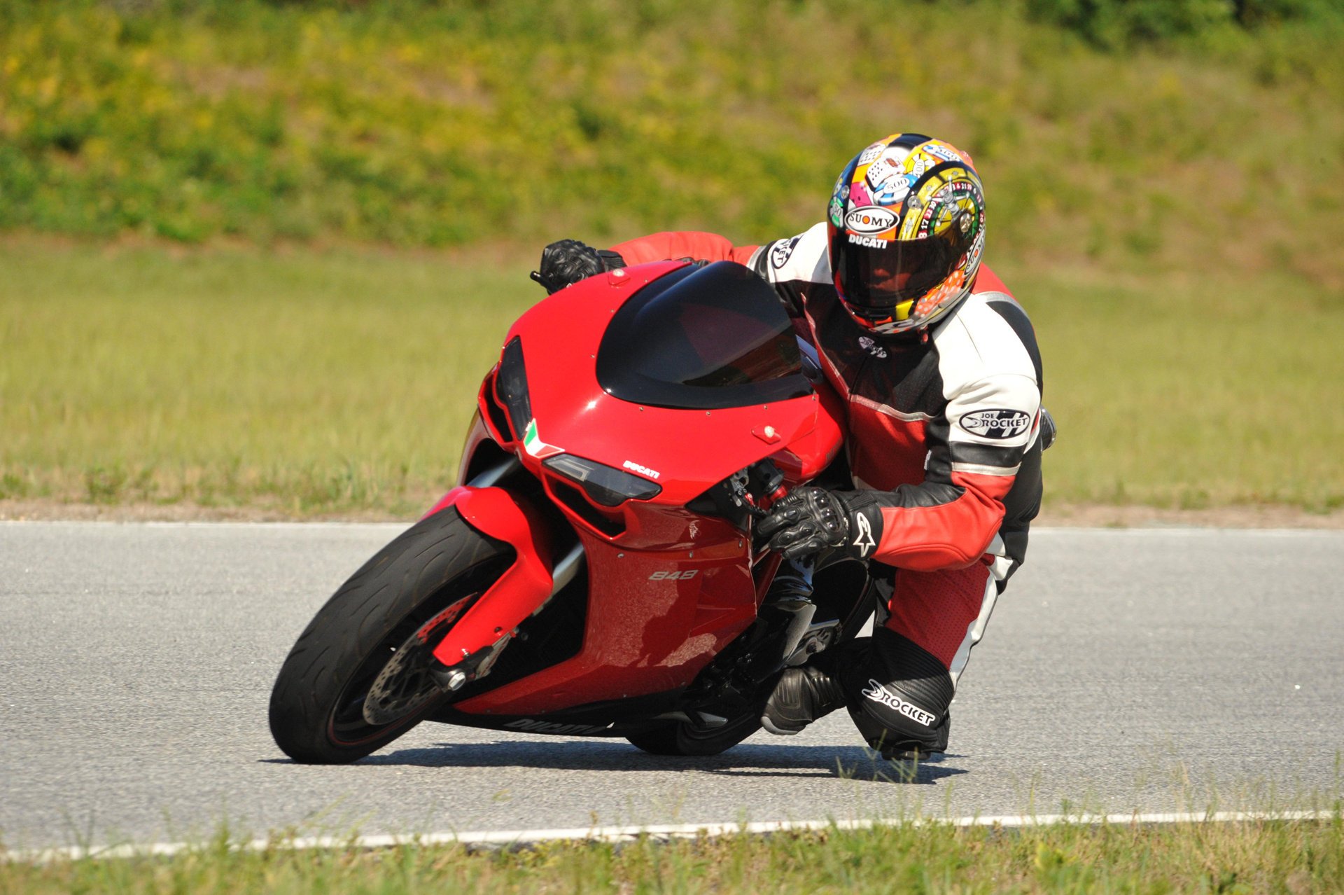 ducati 848 sportbike rosso ducati sportbike motorrad moto rot design italien pilot helm geschwindigkeit extrem straße asphalt rennfahrer grün gras motorrad sport rennen motorsport fahrrad männer motorsport