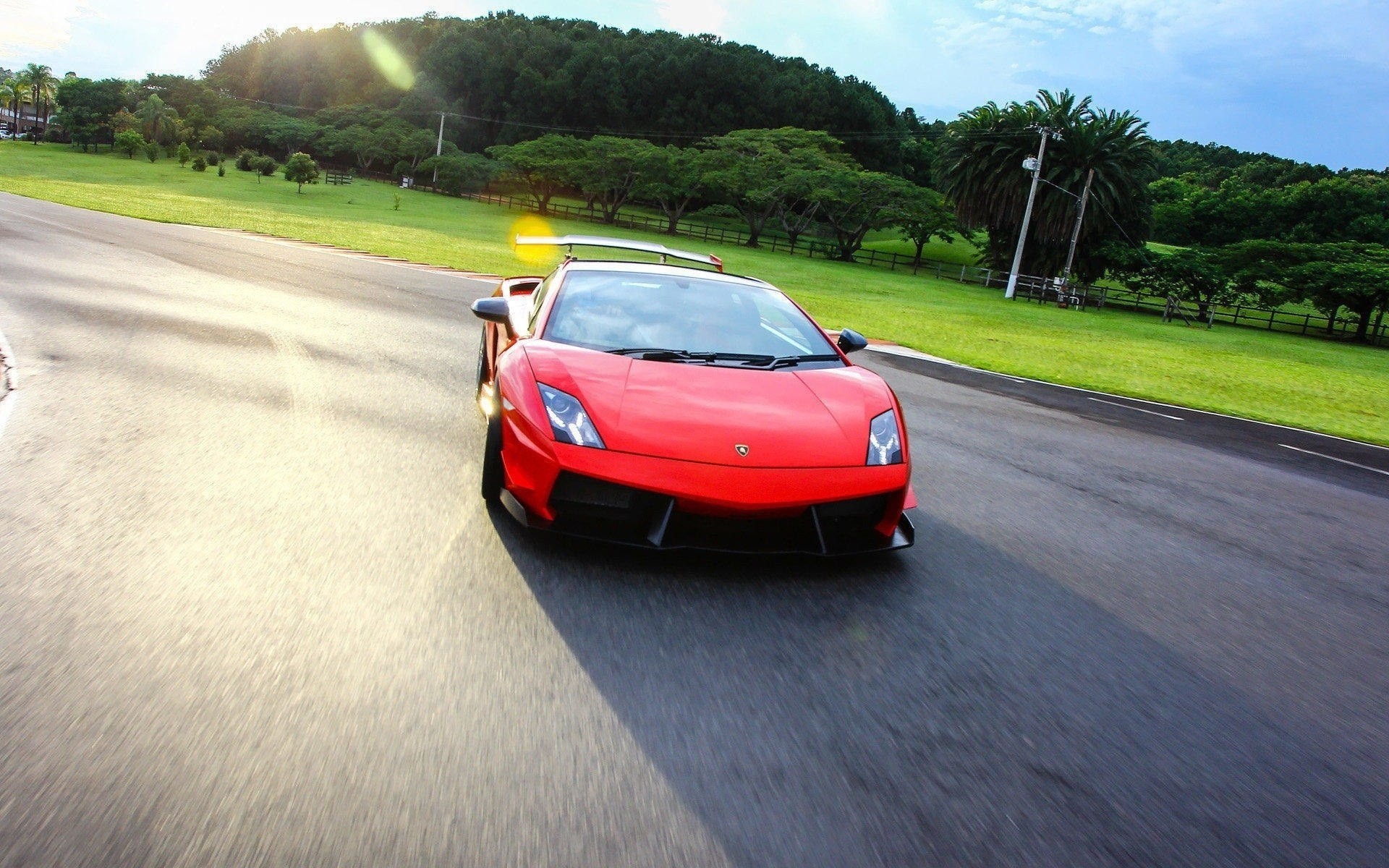 asphalte spoiler rouge nuages piliers arbres herbe lamborghini ciel route voiture phares auto brouette