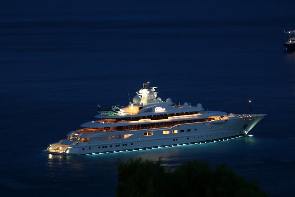 Yacht notturno in mezzo al mare blu con lanterne