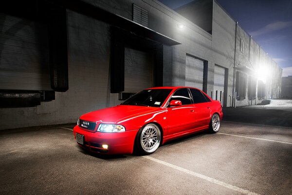 Red audi car with headlights on