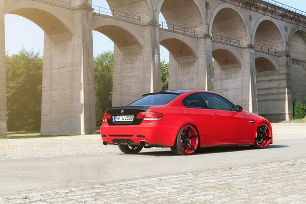 BMW rouge avec tuning parmi les arches