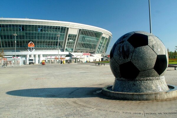 Monument to the ball on the background of the stadium