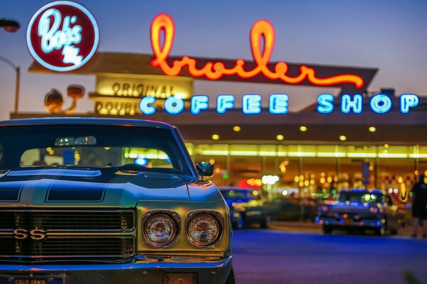 Retro car on the background of coffee. Night and lights