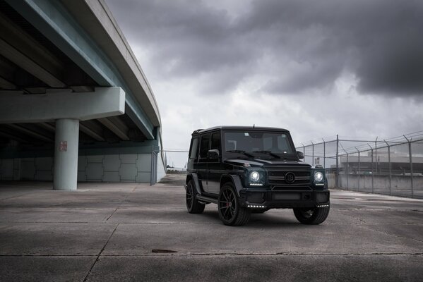 Schwarzer Mercedes g63 auf Brücke und Himmelshintergrund