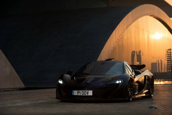 Black tinted McLaren with headlights on