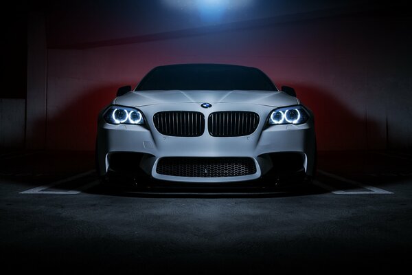 Beautiful white BMW 550 ai car with headlights on