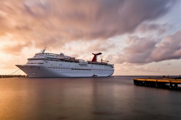 A huge white ship on the background of sunset