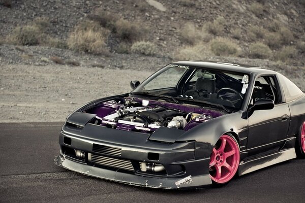 Black Nissan 240sx with pink wheels