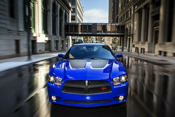 Voiture de sport bleu sur la route mouillée dans la ville