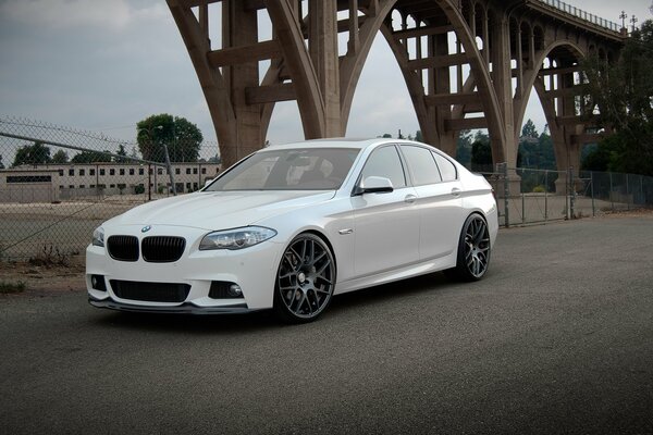 Elegante bianco BMW 550 ai sotto il ponte