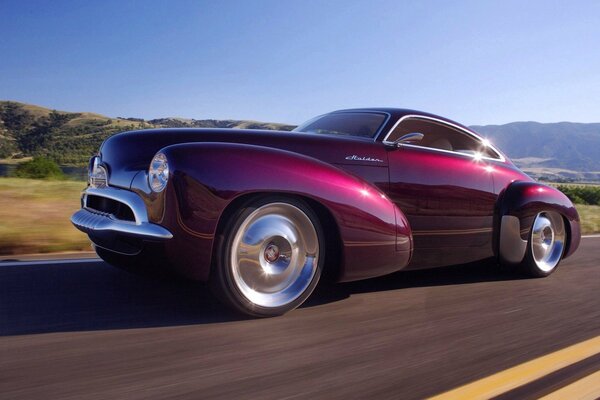 Burgundy Holden racing on a wild mountain highway