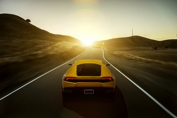 Vue arrière de la voiture jaune lamborghini au coucher du soleil