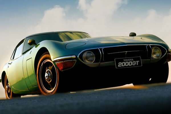 Toyota 2000GT verde en ángulo contra el cielo