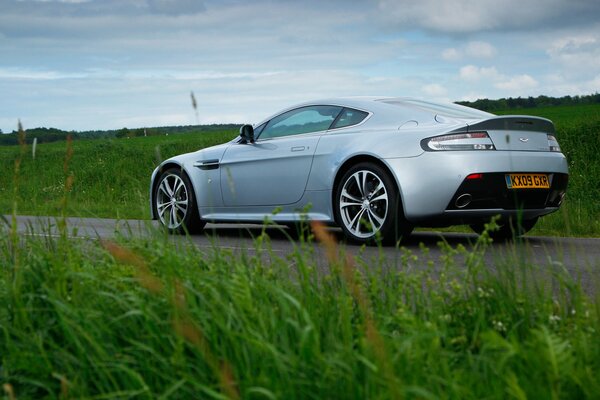 Aston Martin na drodze na tle trawy