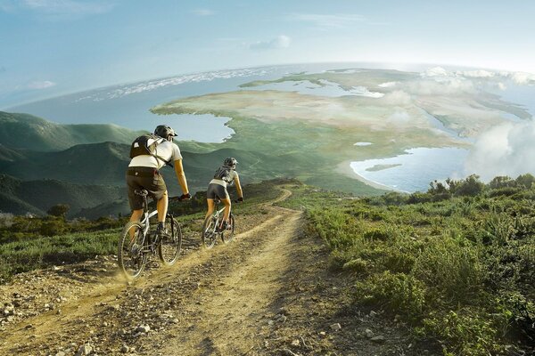 Una coppia sposata va in bicicletta lungo i campi verdi