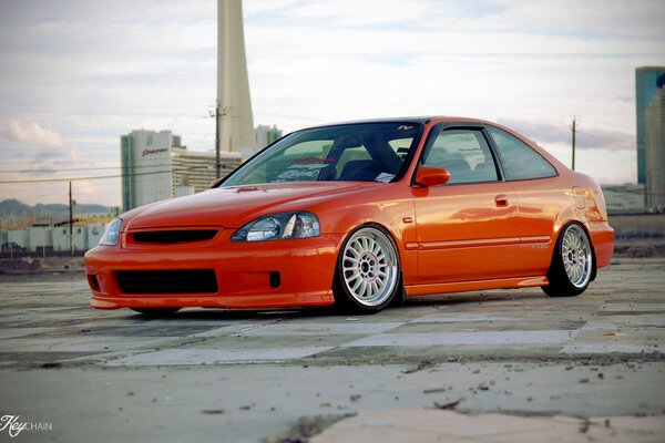 El coche naranja de Honda en el fondo de la ciudad