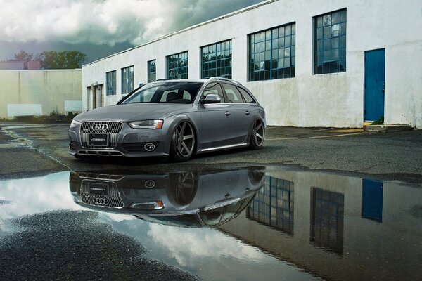 Audi A6 se tient près d une flaque d eau près du bâtiment