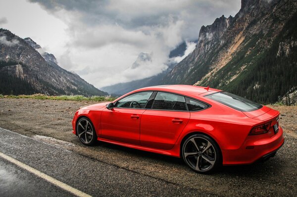 Audi rojo en el fondo de las montañas