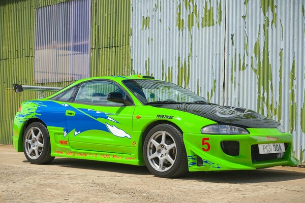 El coche verde se encuentra en el fondo de una pared blanca y verde