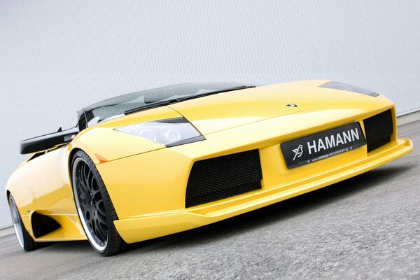 Cool yellow Lamborghini supercar tilted against a white wall