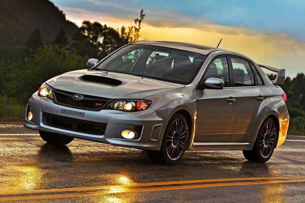 Grey Subaru impreza in motion on a wet track