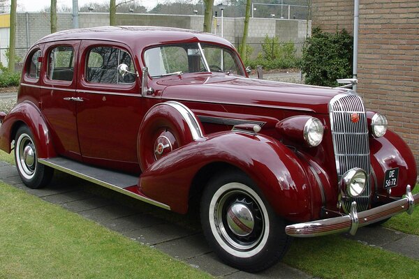 Red retro car near a private house