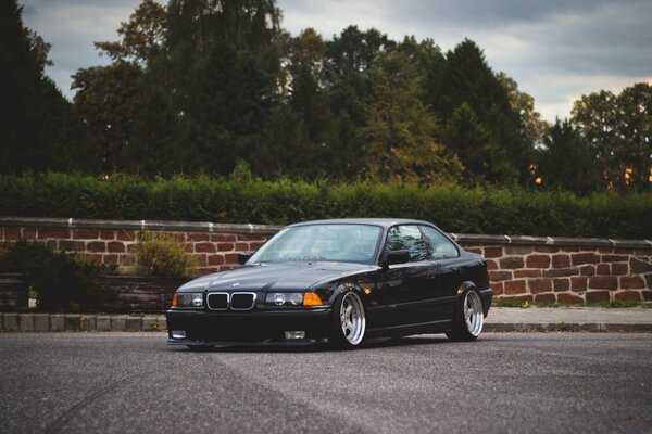 BMW noir sur fond d arbres verts