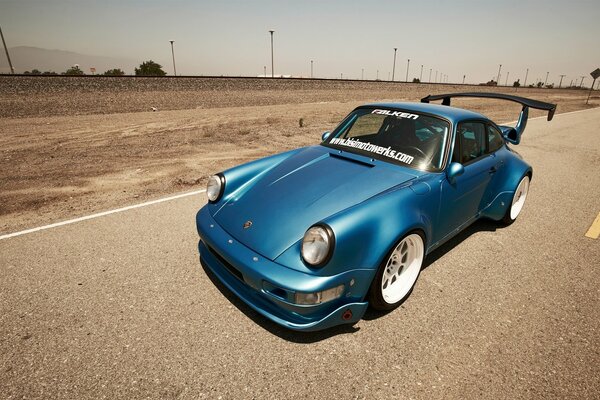 Porsche 911 blue on a deserted highway