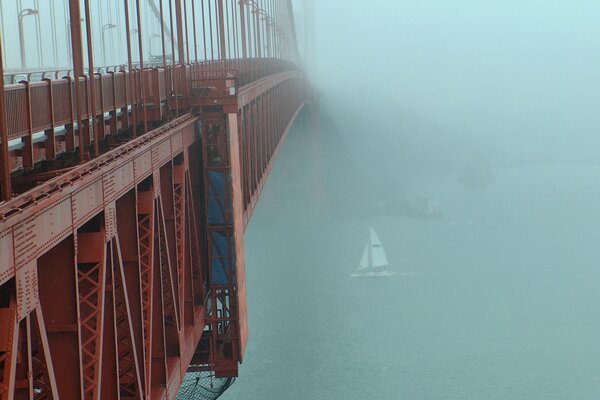 A cable-stayed post in the fog. Sailboat