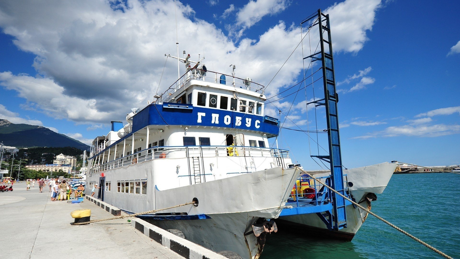 teamers yalta globe promenade pier marina clouds catamaran crimea people vacationers resort summer the sky mountains south coast transport