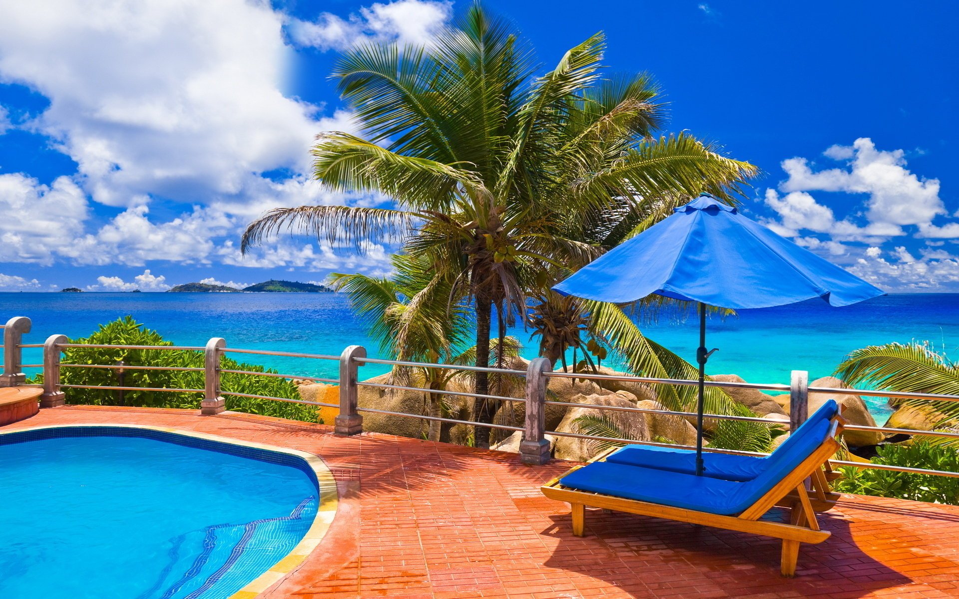 mer piscine palmiers nuages ciel bleu eau bleue chaises longues loisirs parapluie pierres clôture eau ciel