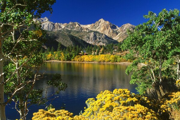 Landscape with a mountain lake on a blue sky background