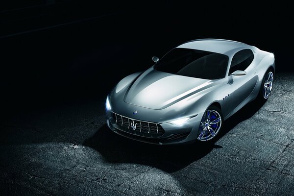 Beautiful maserati at night on the street under a street lamp