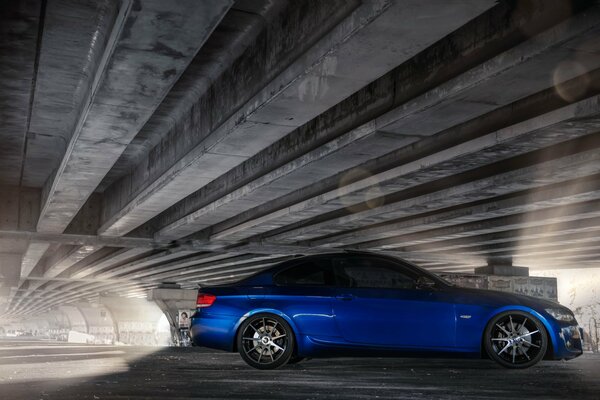 Tuned BMW under the bridge in the rays of light