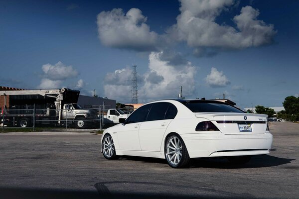 White BMW on the street against the sky and houses