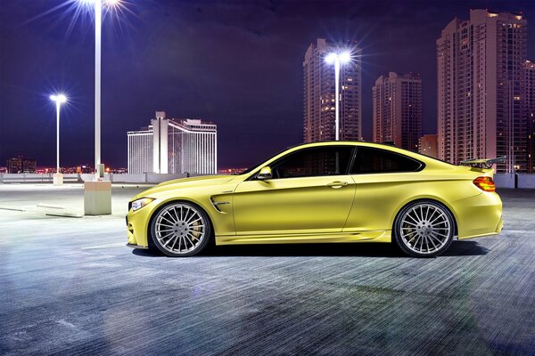 Yellow BMW m4 on the background of the night city