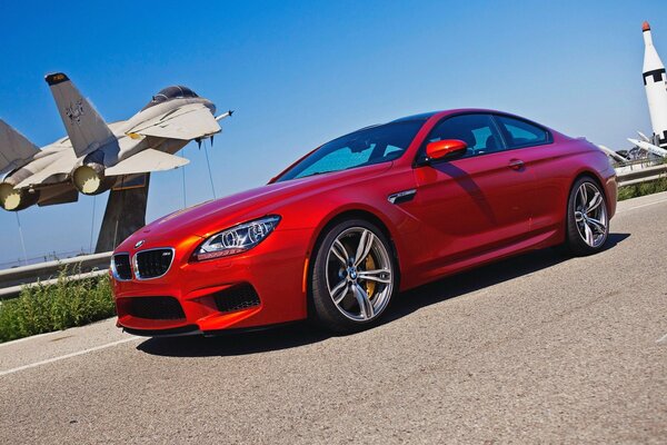 Roter bmw m6 auf Flugzeughintergrund