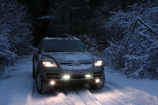 SUV in the middle of a winter forest on a narrow road