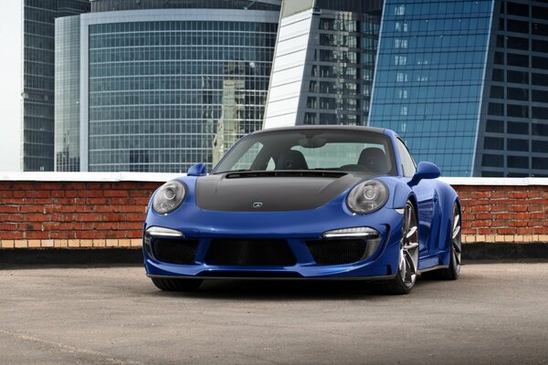 Blue sports car on the roof - high-rise buildings