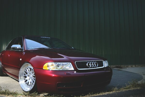 Audi A4 on the background of a green ribbed fence