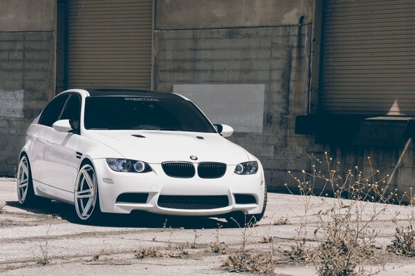 Blanc BMW stomt sur le parking à côté du bâtiment