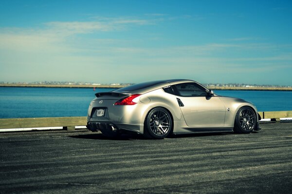 Silver Nissan 370Z se déplace le long de la rivière