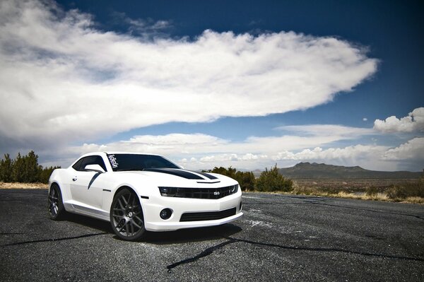 Chevrolet blanc sur fond de montagnes et de nuages