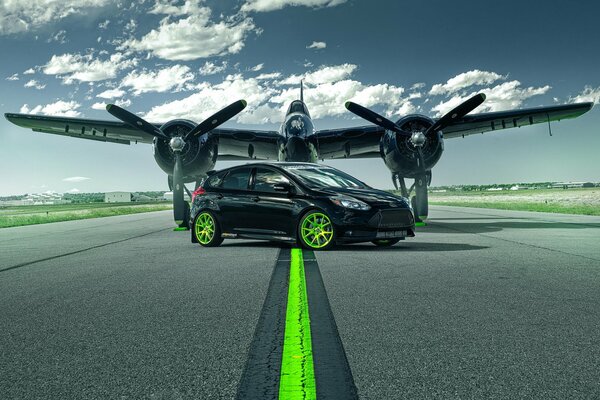 The car next to the plane on the runway