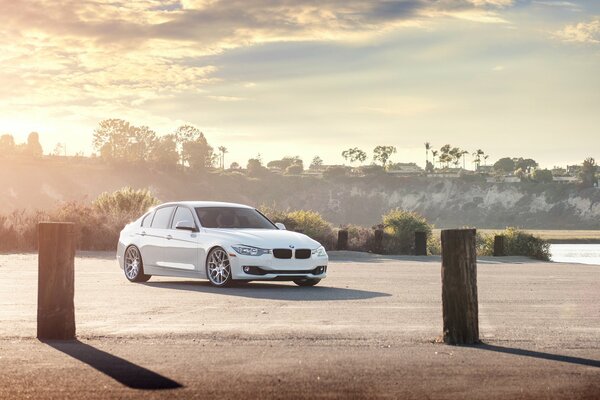 White BMW sedan on sunset background