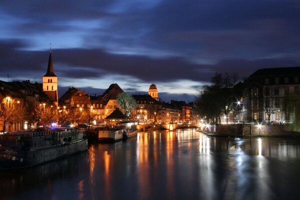 Die Lichter der Stadt spiegeln sich im Fluss wider